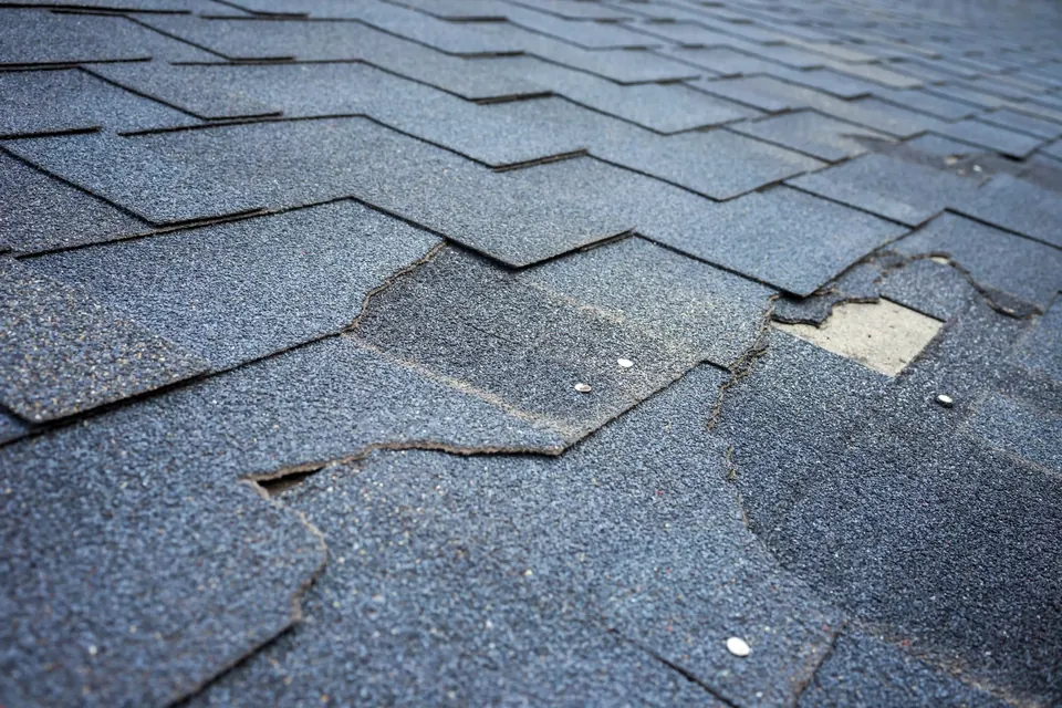 Close-up of cracked and lifted asphalt shingles
