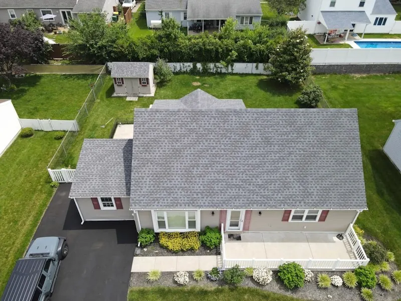 Aerial view of a ranch house with a newly installed gray shingle roof