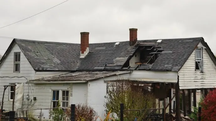 Older two-story house with a worn roof
